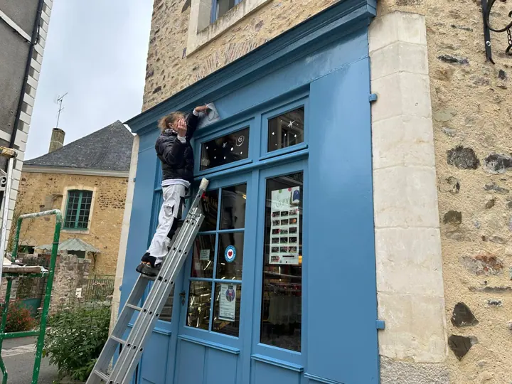 Décor et lettrage peints sur la vitrine d'un commerce, étape 5
