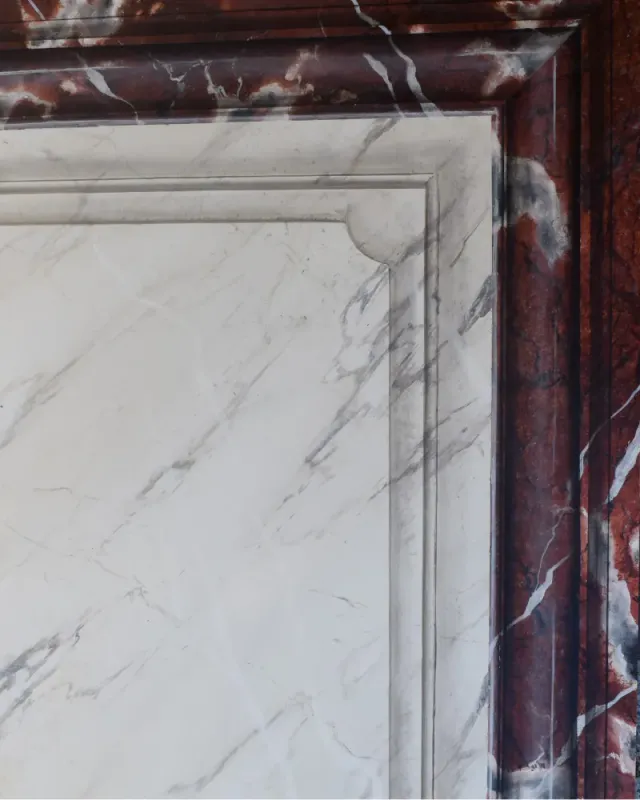 Faux encadrement en marbre peint autour d'un miroir